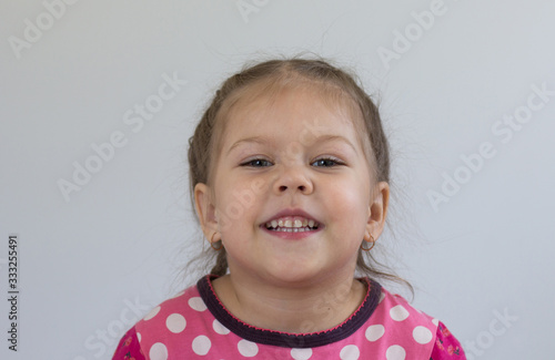 Portrait of smiling caucasian child of three years old looking at camera on the white background