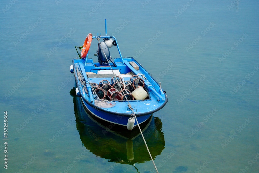 La barca azul esta amarrada en aguas transparentes