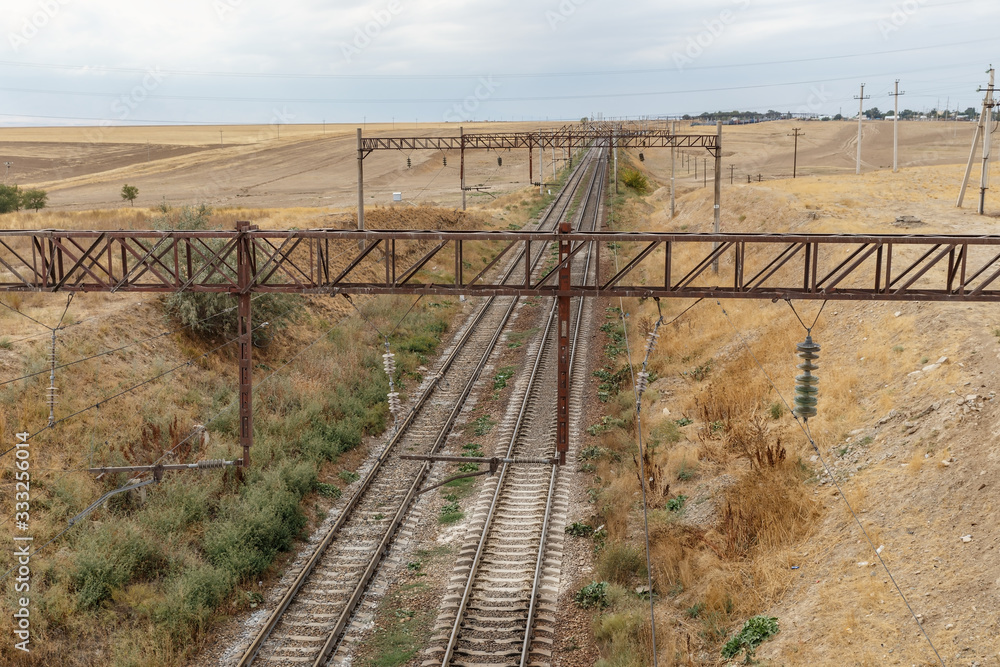The railway in steppe of Kazakhstan, view of the rails from the bridge. The railway in steppe of Kazakhstan, view of the rails from the bridge.