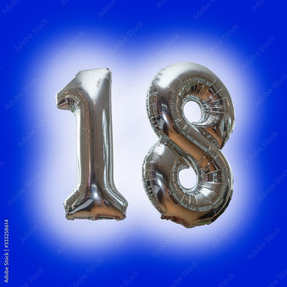 Silver number 18 party balloons isolated on a blue background Silver number 18 party balloons isolated on a blue background