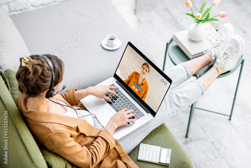 Business woman having a video call with coworker, working online from home at cozy atmosphere. Concept of remote work from home photo