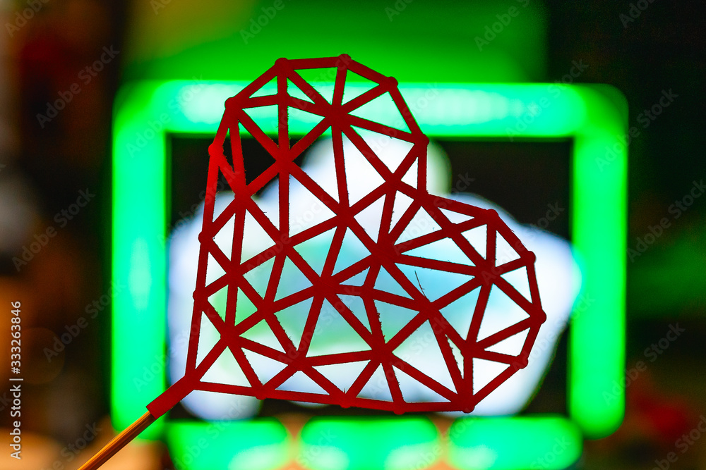 the red figure in the shape of a heart in a green glowing box. symbol of love and friendship