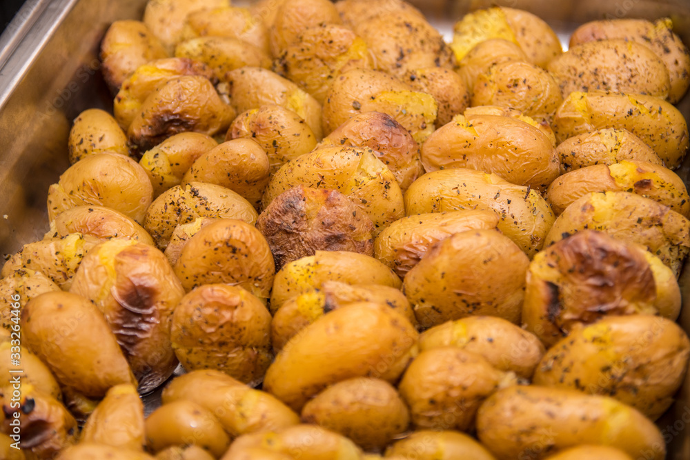 Close up of golden roasted potatoes in skin with oregano Close up of golden roasted potatoes in skin with oregano