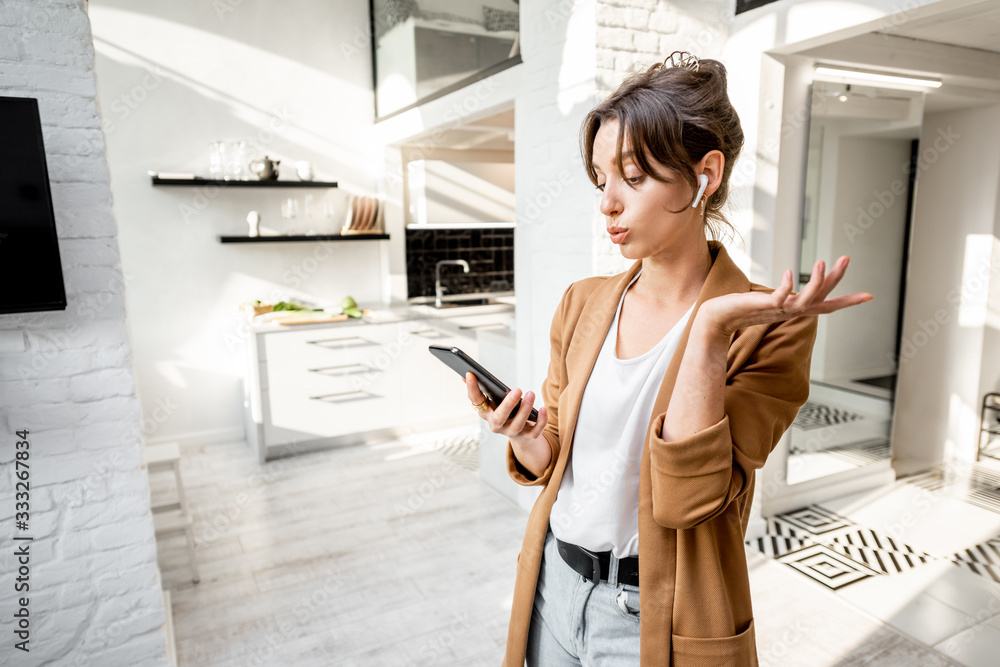 Well-dressed woman having some business work on a smart phone while working from home Well-dressed woman having some business work on a smart phone while working from home