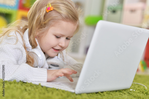 Close up portrait of girl with headphones using laptop