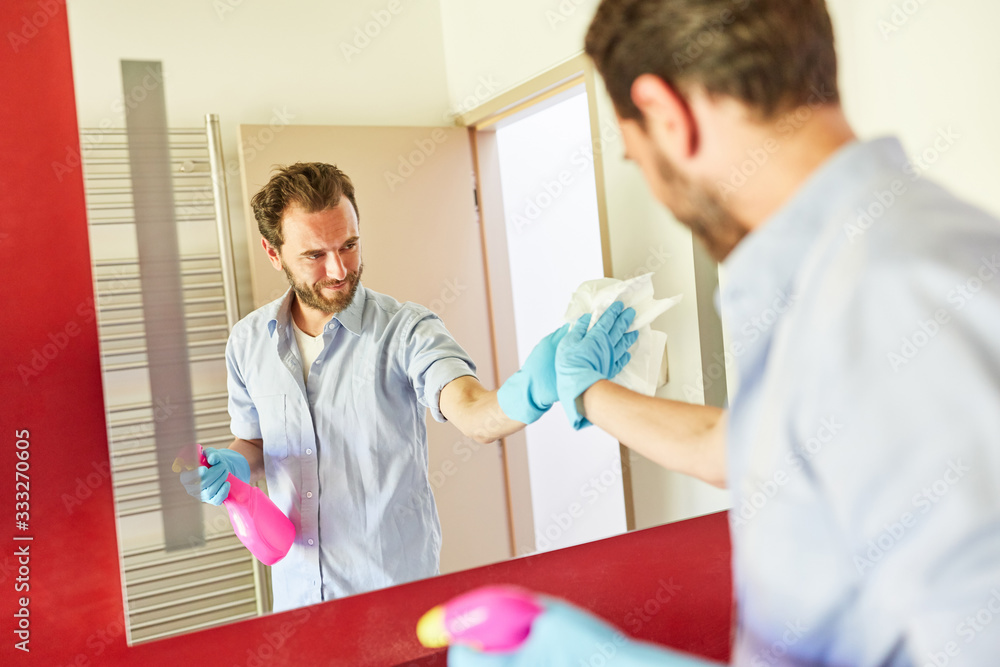 Obraz premium Clean the housekeeper with cleaning cloth at the mirror