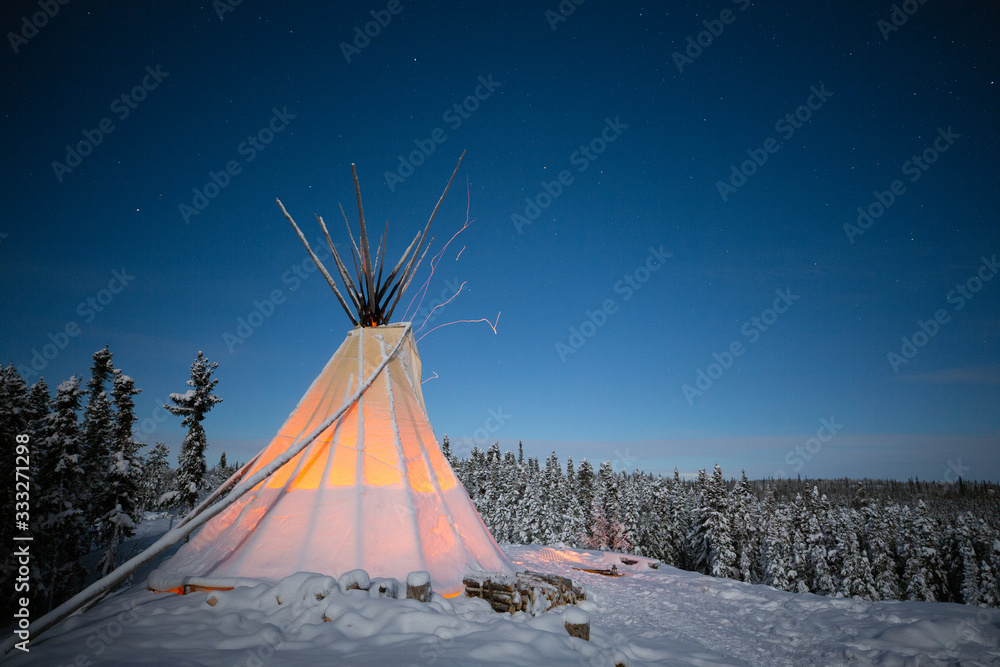 Glowing teepee in the night in the winter forest, Yellowknife, Northwest Territories, Canada Glowing teepee in the night in the winter forest, Yellowknife, Northwest Territories, Canada