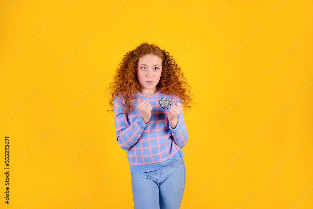 red curly girl on a yellow background, happy red curly girl on a yellow background, happy