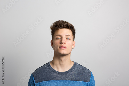 Portrait of young man standing against white background