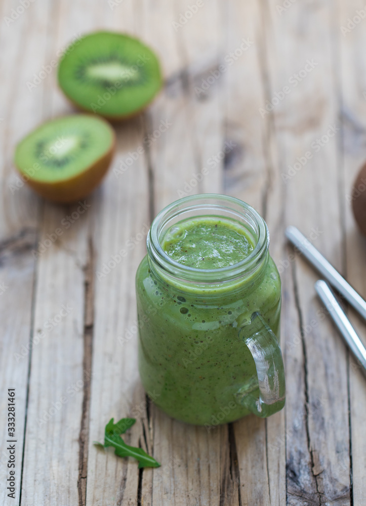 Vegan smoothie drink with kiwi, banana and rucola in a jar on a wooden background in rustic style Vegan smoothie drink with kiwi, banana and rucola in a jar on a wooden background in rustic style