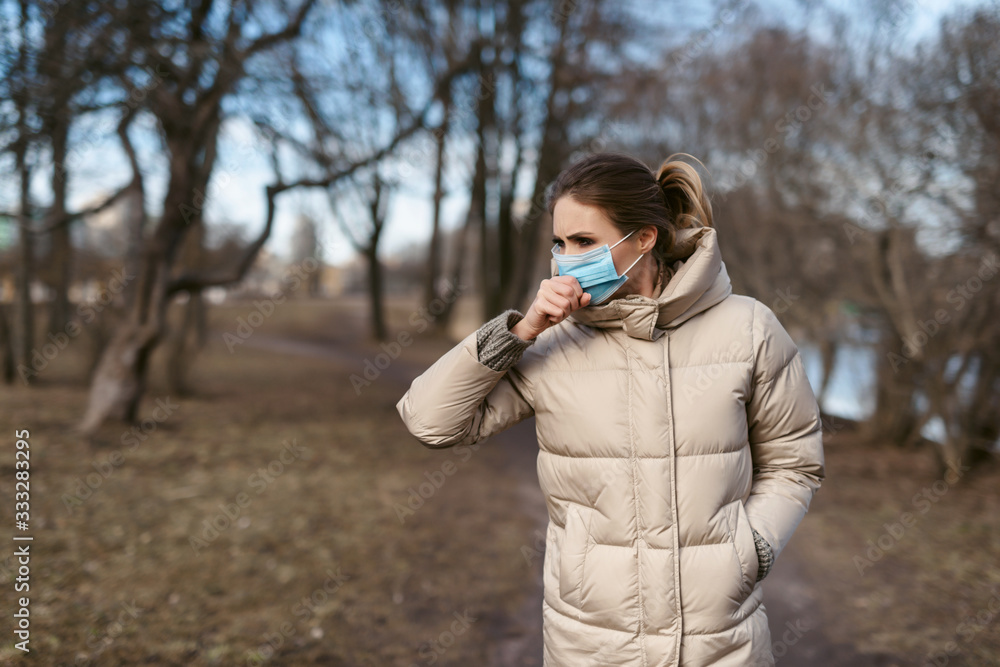 Prevention of coronavirus outbreak in 2020. Outdoor portrait of young european woman wearing a disposable facial mask. Prevent pollution and disease concept. Prevention of coronavirus outbreak in 2020. Outdoor portrait of young european woman wearing a disposable facial mask. Prevent pollution and disease concept.