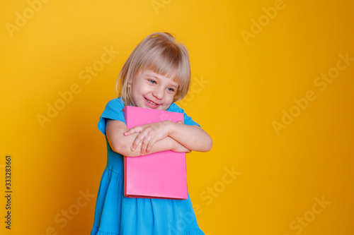 a little girl holds a book in her hands