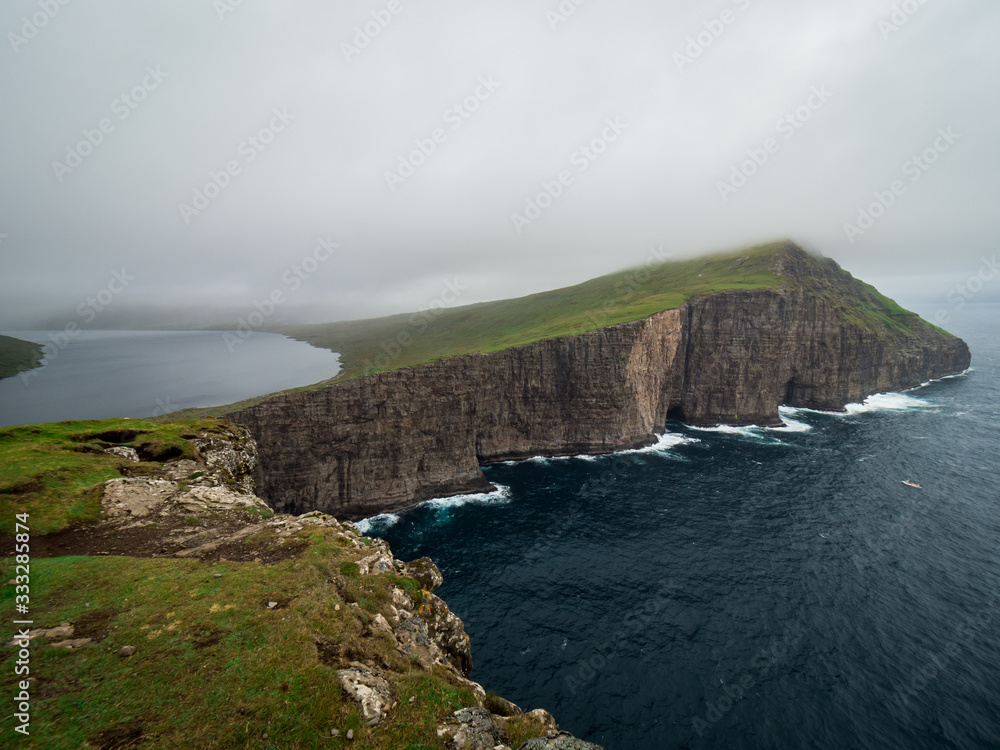 Faroe Islands. Trælanípan. View form Slave Cliffs on the lake Leitisvatn hanging over the ocean.
