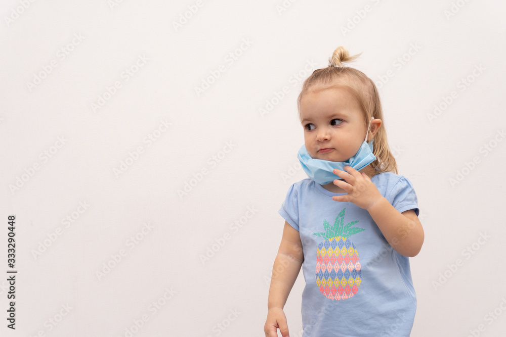 Cute little blond caucasian child with facial protective mask at the time of world self isolation period, world quarantine concept, white background Cute little blond caucasian child with facial protective mask at the time of world self isolation period, world quarantine concept, white background