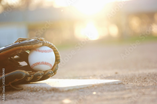 Photography Baseball glove and ball on field during sunset with blurred background