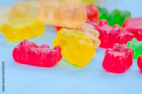 Lots of colorful multi-colored jelly bears on a blue background, macro