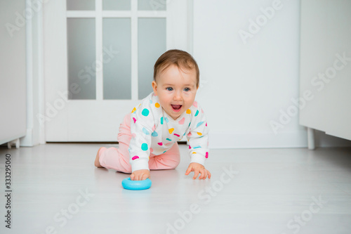 Toddler girl plays educational games at home. Baby sits on the floor of the house