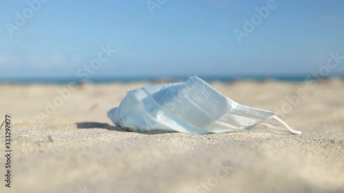 medical protective mask for coronavirus protection on the sunny sand beach in a tropical country photo