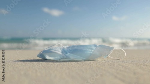 medical protective mask for coronavirus protection on the sunny sand beach in a tropical country photo