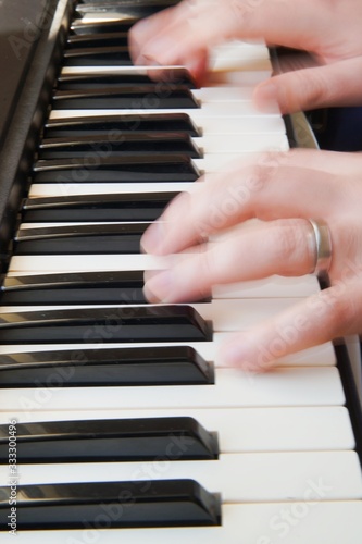 Two blured hands play the piano