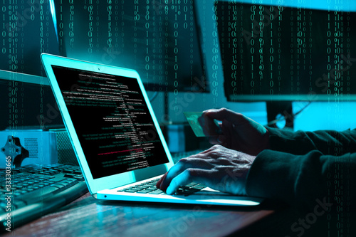 Slika na platnu Cyber criminal with credit card hacking system at table, digital binary code on