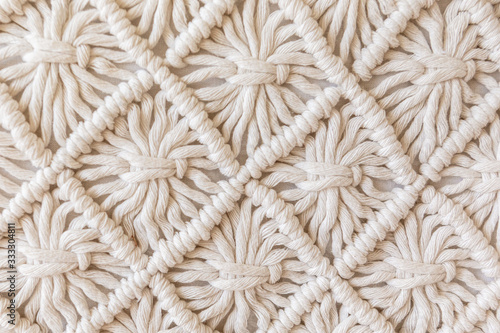 Close-up of hand made macrame texture pattern. ECO friendly modern knitting DIY natural decoration concept. Flat lay.
