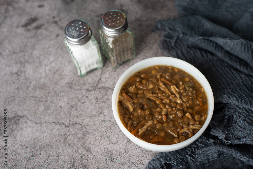 A bowl of lentil soup with chicken, Mediterranean soup with thick stew like broth. A bowl of lentil soup with chicken, Mediterranean soup with thick stew like broth.