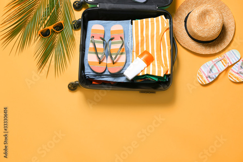 Fotografie, Obraz Flat lay composition with open suitcase on orange background