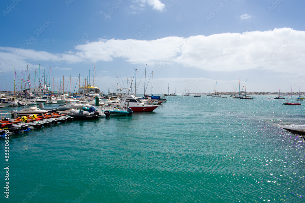 Fototapeta premium Corralejo, Fuerteventura, Canary Islands, Spain: Boats and Yachts in Corralejo Port, calm ocean water 