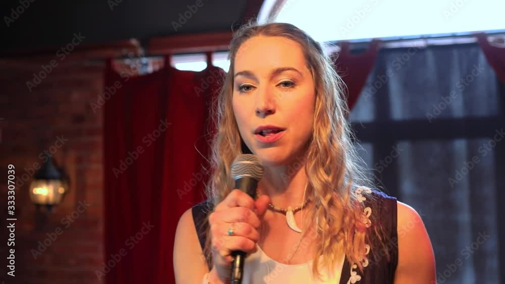 Portrait of beautiful and confident adult woman sharing ideas and thoughts with an intimate audience in a small authentic venue Portrait of beautiful and confident adult woman sharing ideas and thoughts with an intimate audience in a small authentic venue