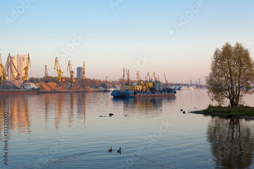 Barge and construction cranes on a river