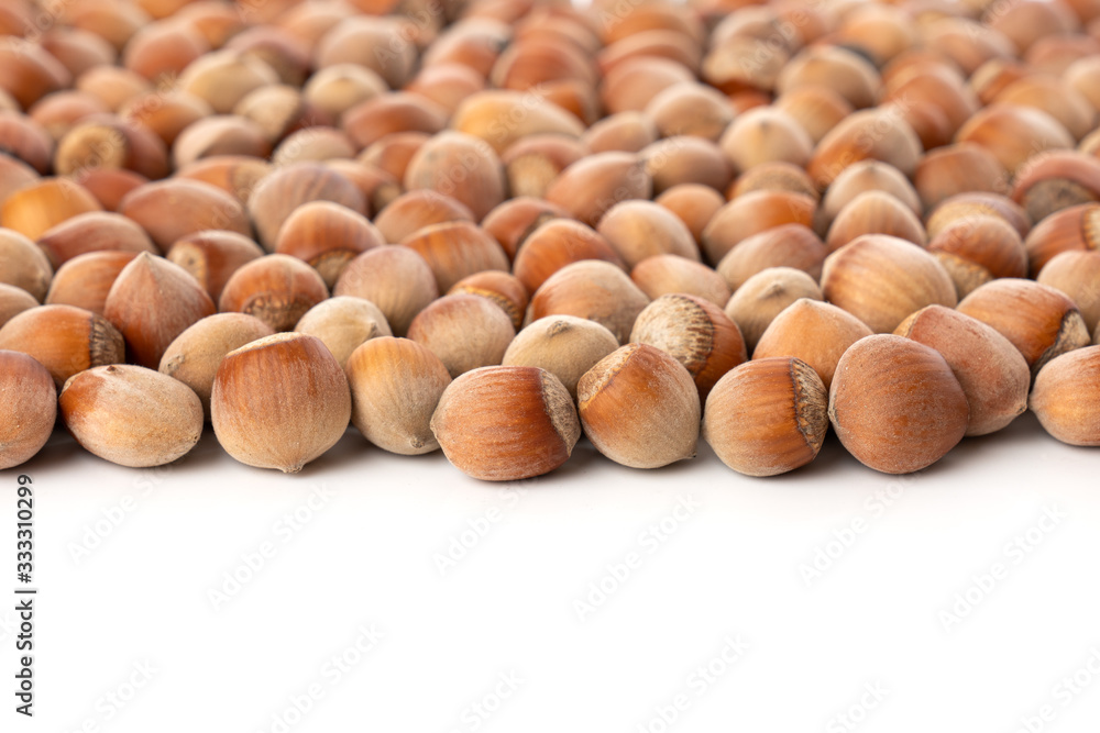 Close up view of shelled Hazelnuts isolated on white. Heap of Hazelnuts as background. Close up view of shelled Hazelnuts isolated on white. Heap of Hazelnuts as background.