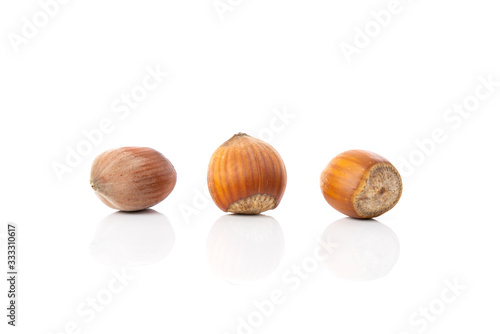 Close up of a three hazelnuts isolated over white background