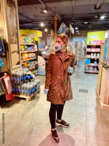 girl in a protective mask and gloves against coronavirus in a supermarket. beautiful young woman. grocery store. Russian girl. Covid-2019.