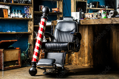 Hairstylist in barbershop interior. Barber shop chair. Barbershop armchair, salon, barber shop for men. Barber shop pole. Logo of the barbershop, symbol photo