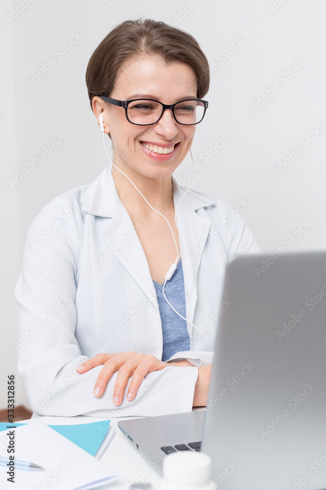 Portrait of a smiling female doctor consulting patient by video call in online chat on computer. The doctor contacts the client at the conference, talks on the webcam. Portrait of a smiling female doctor consulting patient by video call in online chat on computer. The doctor contacts the client at the conference, talks on the webcam.