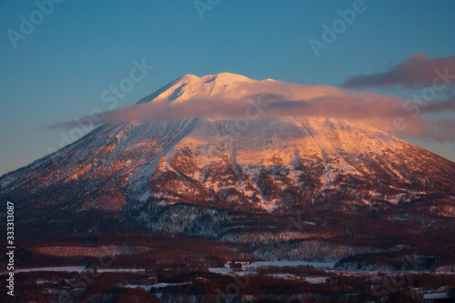 Mount Yotei during a pink sunset in the clouds at Lake Toya in Japan photo