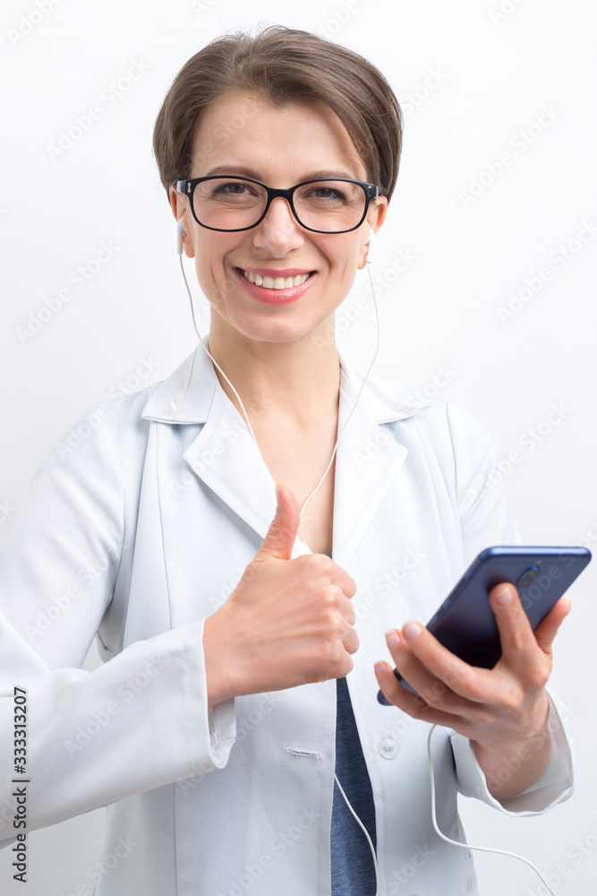 Portrait of a happy female doctor holding thumbs up from video call in online chat on mobile phone. Portrait of a happy female doctor holding thumbs up from video call in online chat on mobile phone.