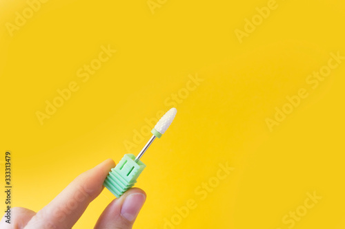 Nail Care Concept. Cutters for hardware manicure and pedicure on a yellow background