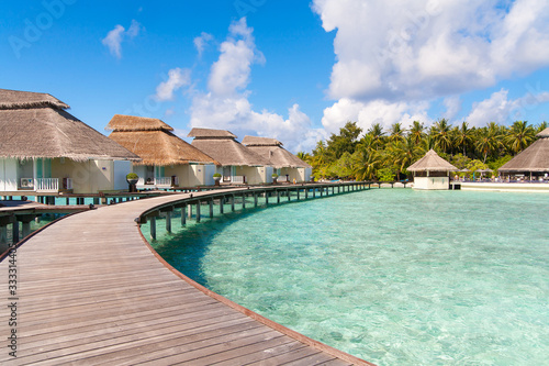 A view at the beach and waterhuts at tropical island, Maldives photo