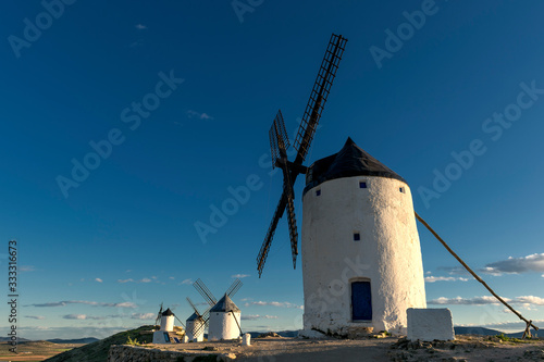 Group of old windmills in the town of Consuegra (Spain), on the route of the Don Quixote and Cervantes mills, at sunset.