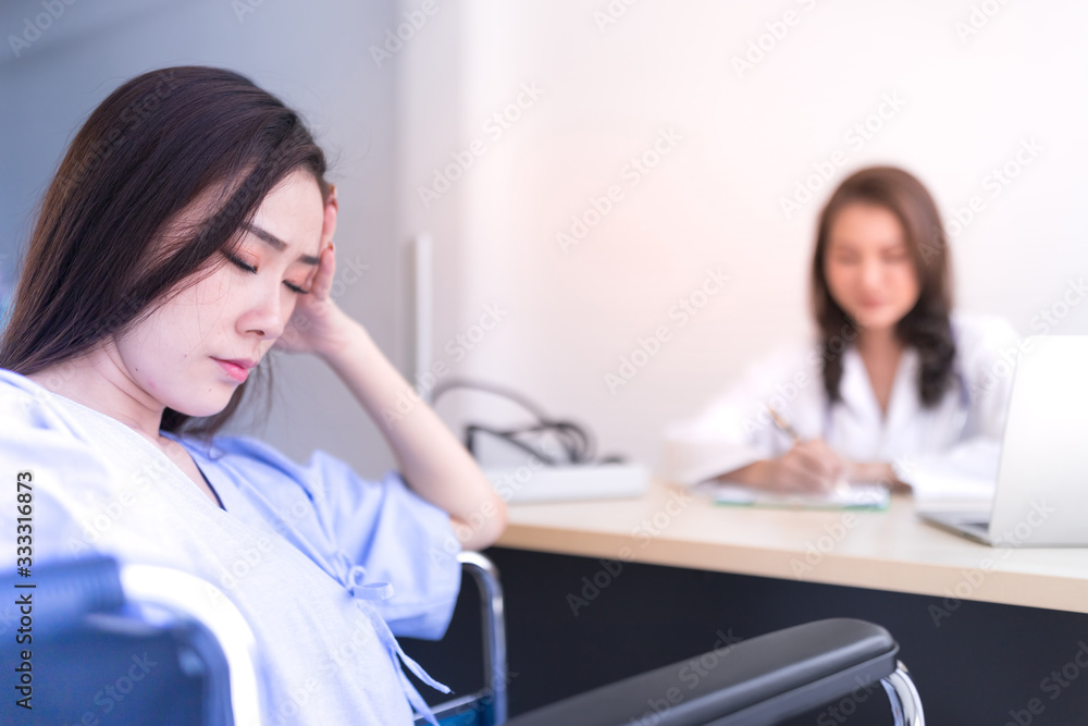 An Asian female patient is sleeping on a wheelchair in the examination room. An Asian female patient is sleeping on a wheelchair in the examination room.