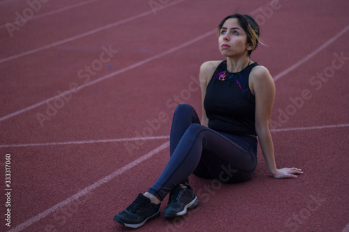 woman tired of doing sports, sitting on the track