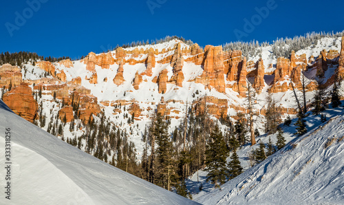 Desert sandstone rock formations in winter snow on a clear sunny day.