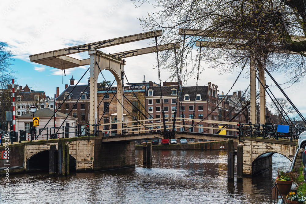Antique iron drawbridge in water channel of Amsterdam, empty streets without people, Coronavirus Epidemic, city quarantine, COVID-19 outbreak. Antique iron drawbridge in water channel of Amsterdam, empty streets without people, Coronavirus Epidemic, city quarantine, COVID-19 outbreak.