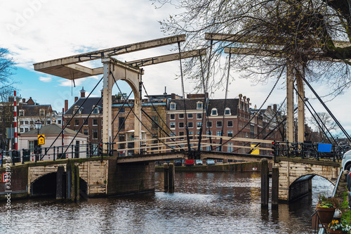 Antique iron drawbridge in water channel of Amsterdam, empty streets without people, Coronavirus Epidemic, city quarantine, COVID-19 outbreak.