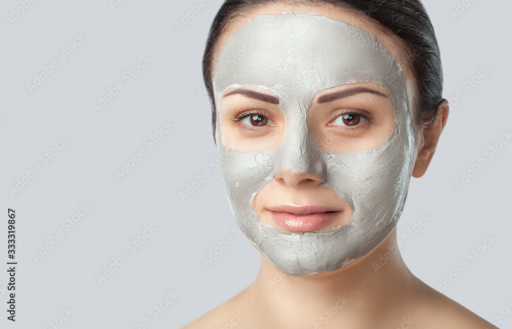 Beautician makes a face clay mask against acne on the face of a woman to rejuvenate the skin.treatment of problem skin on the face and body. Cosmetology and professional skin care. Beautician makes a face clay mask against acne on the face of a woman to rejuvenate the skin.treatment of problem skin on the face and body. Cosmetology and professional skin care.