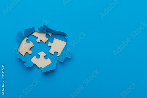 World Autism Awareness, concept with puzzle or jigsaw pattern in paper cut hole. Blue background