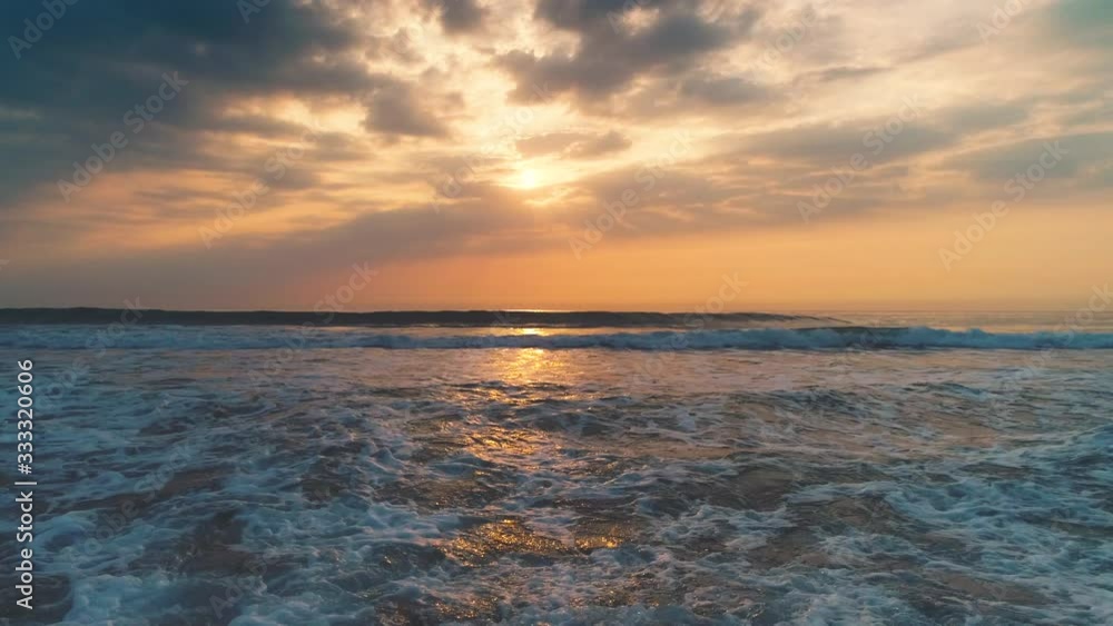 Sea sunrise and splashing waves on the sand Sea sunrise and splashing waves on the sand