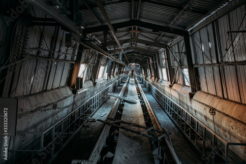 Abandoned cement and concrete factory. Old rusty conveyor in corridor